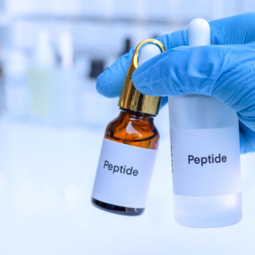 a blue gloved hand holding one amber bottle and one opaque dropper bottle with the word peptide in black bold print on the front of each bottle #peptidetherapy #peptidebenefits #peptideuses #peptide side effects