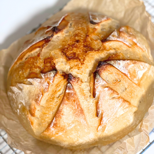 sourdough boule with trees carved in it on a wire baking rack