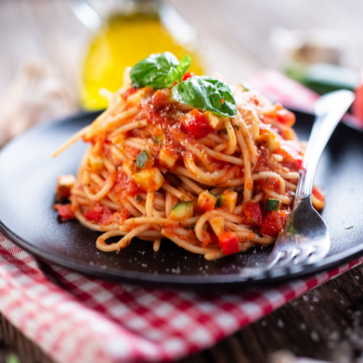 plate of piled-high spaghetti with basil leaves on top