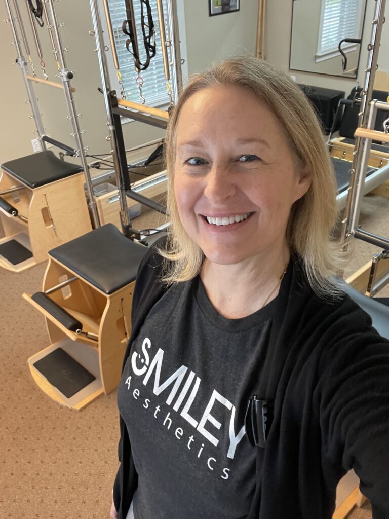 kelly in a smiley asethetic shirt at the pilates studio