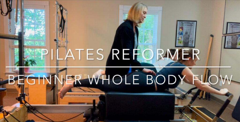 Kelly teaching 2 Pilates clients on the reformer performing swan facing front