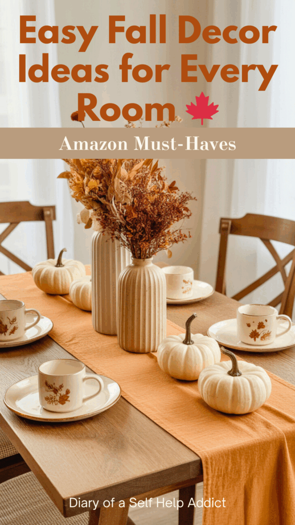 A rustic wooden table with a warm-toned table runner, mini faux pumpkins, dried flower arrangements in neutral vases, and a set of fall-themed mugs.