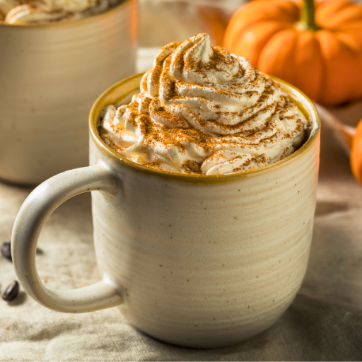 pumpkin spice latte in a neutral colored mug with pumpkins on the table nearby