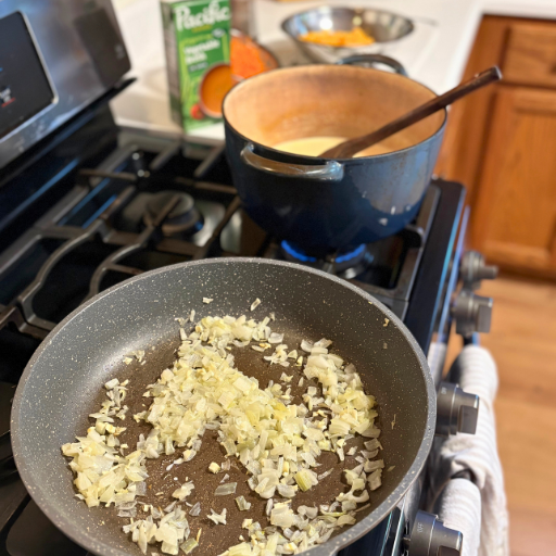 onions and garlic cooking on the stovetop with the other ingredients next to it