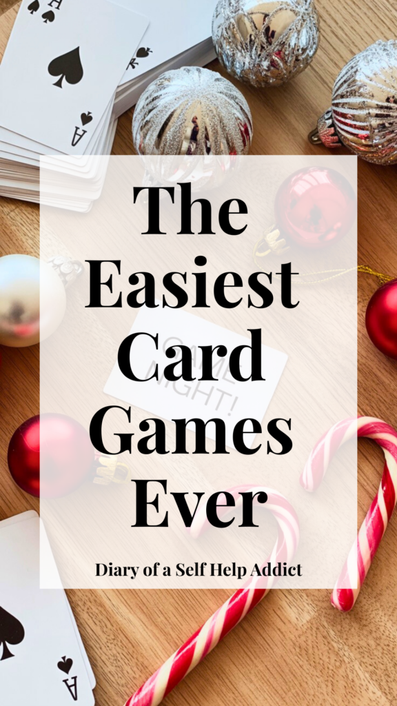 A flat lay of a deck of cards, shiny holiday ornaments, candy canes, and a handwritten “Game Night!” card on a wooden table. Bright, clean, Pinterest-friendly aesthetic.