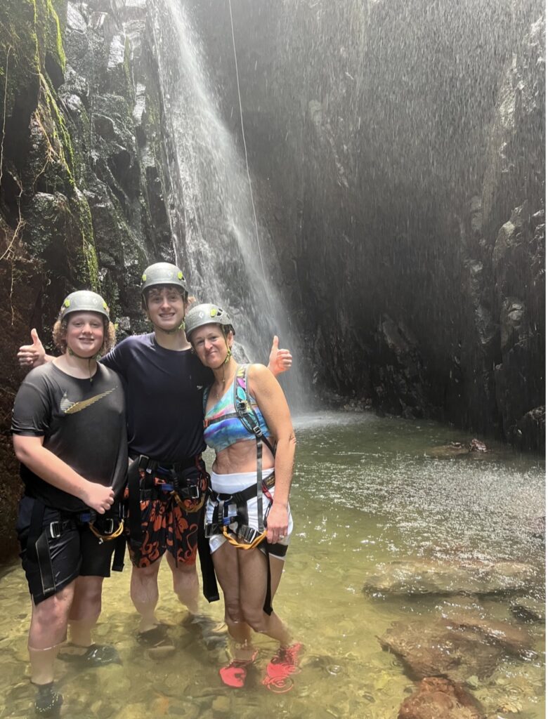 mom and her two sons at a waterfall in Puerto Rico