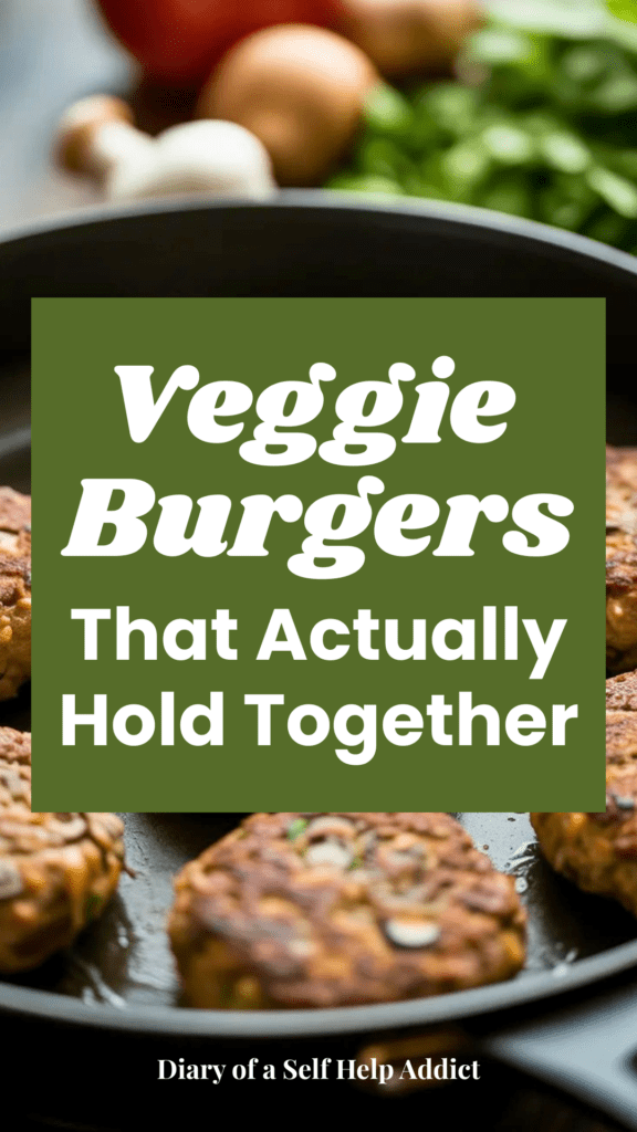 A skillet shot of veggie burger patties sizzling while becoming golden brown and crispy, with visible mushrooms and lentils in the texture and fresh ingredients blurred in the background.