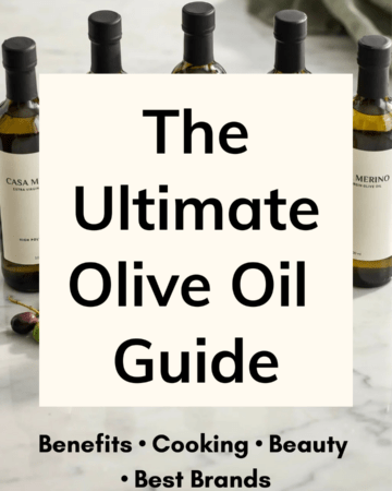 Five elegant bottles of premium extra virgin olive oil displayed on a white marble countertop beside fresh olives, olive branches, small tasting cups, and labels reading "High Polyphenols," "Cold Pressed," and "Extra Virgin," creating the feel of a gourmet olive oil tasting.