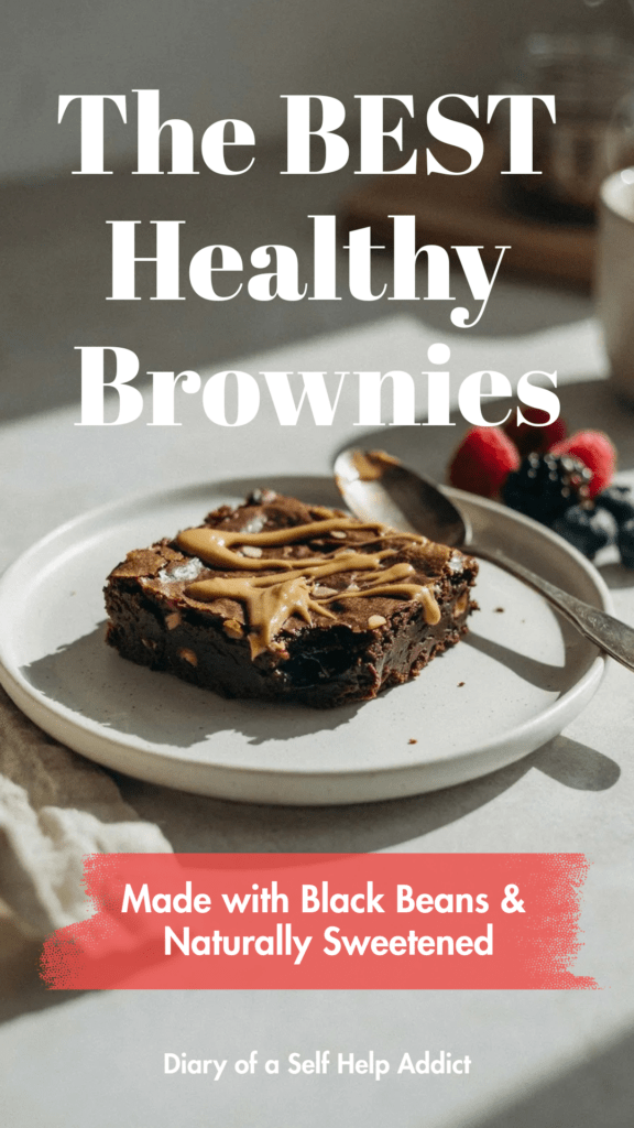 A brownie served warm with a spoonful of almond butter drizzled over the top and fresh berries on the side. Neutral kitchen background with soft morning sunlight.