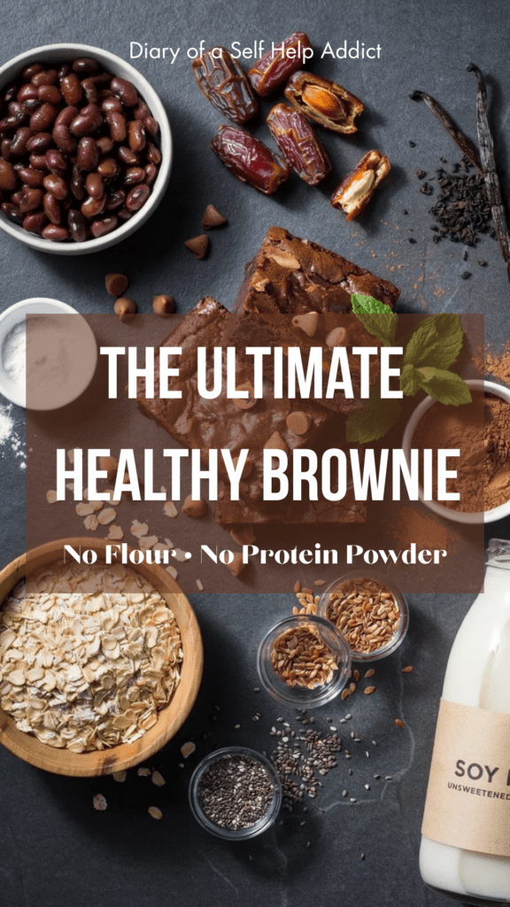 Ingredients beautifully arranged flat lay style: black beans, dates, soy milk, rolled oats, cocoa powder, flaxseed, chia seeds, vanilla, baking powder, Lily's chocolate chips, and a sliced brownie in the center.