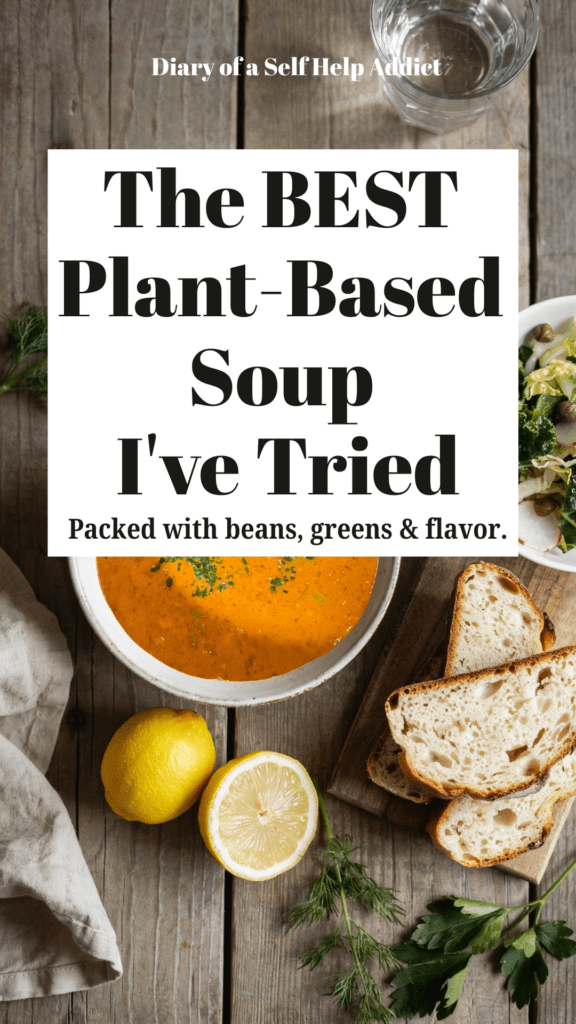 A rustic white bowl filled with creamy lemony chickpea soup topped with fresh dill, cracked black pepper, and a drizzle of extra virgin olive oil. Served with slices of homemade sourdough bread and a crisp kale and cabbage salad on a wooden table with fresh lemons and herbs nearby.