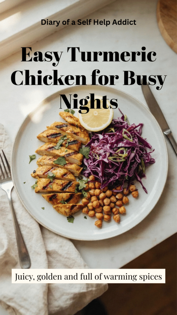 A close, slightly angled photograph of juicy sliced chicken breast coated in a golden turmeric and garam masala yogurt marinade. Show the lightly browned edges and moist interior, with a few crispy chickpeas and strands of purple cabbage softly blurred in the background. Use warm natural light to emphasize the turmeric color and texture. Include a small spoon or bowl of the golden marinade ingredients nearby, but keep the cooked chicken as the clear focus.